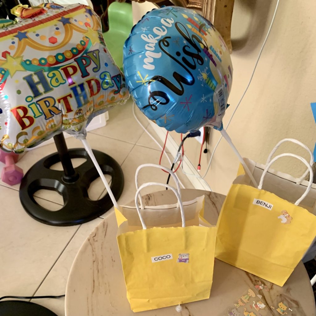 Balloon sticks next to yellow gift baggies