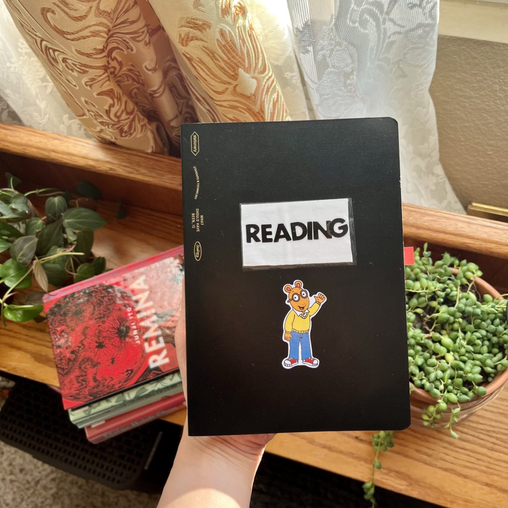 Black reading journal with Arthur sticker on it